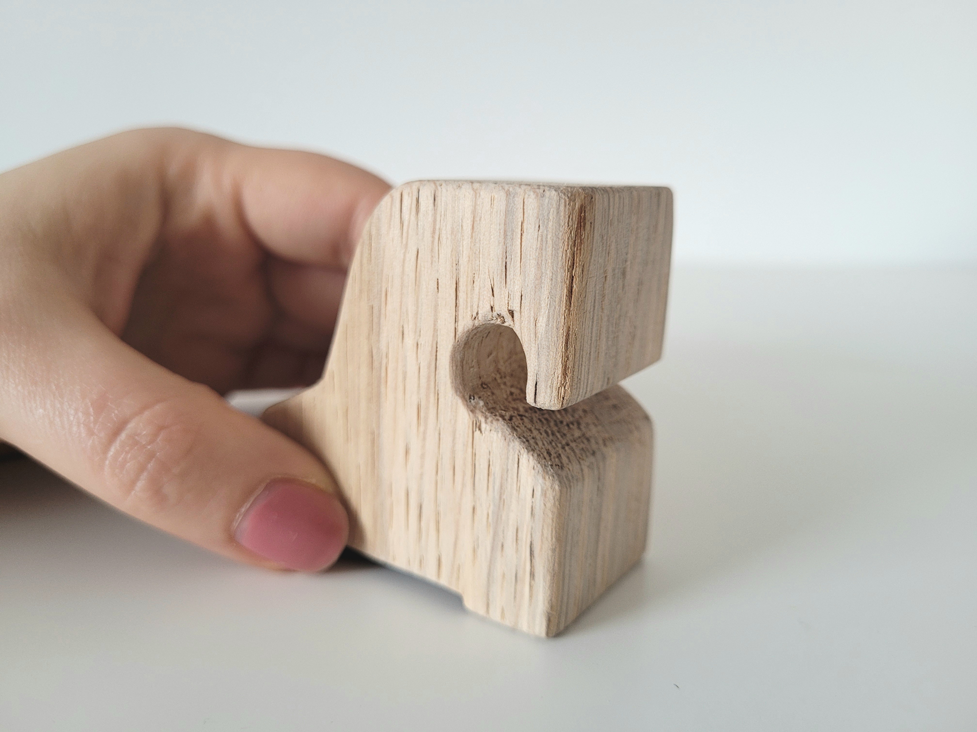 Eine Hand hält ein Holzpferdchen.